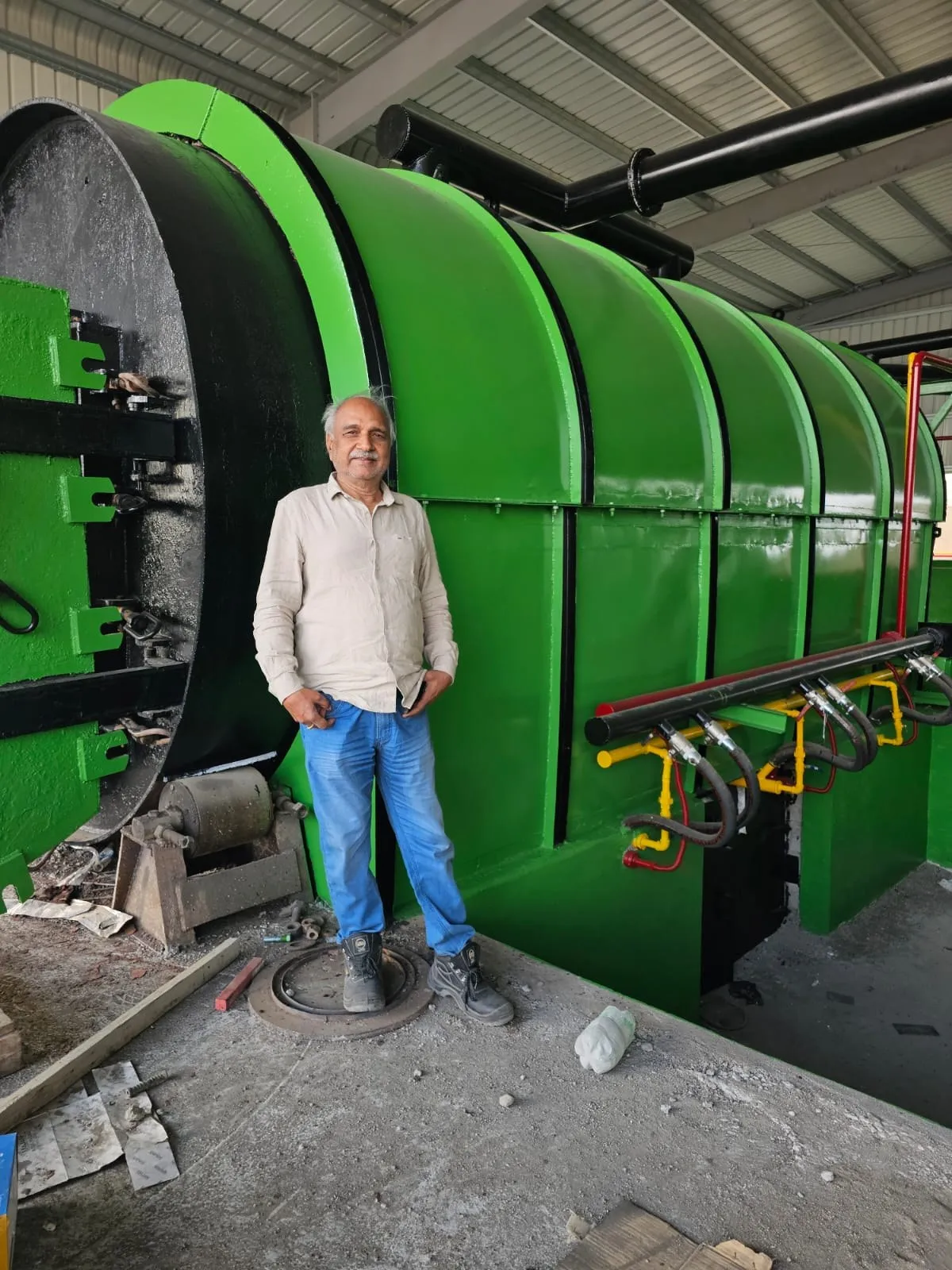 Team member standing in front of a green pyrolysis reactor