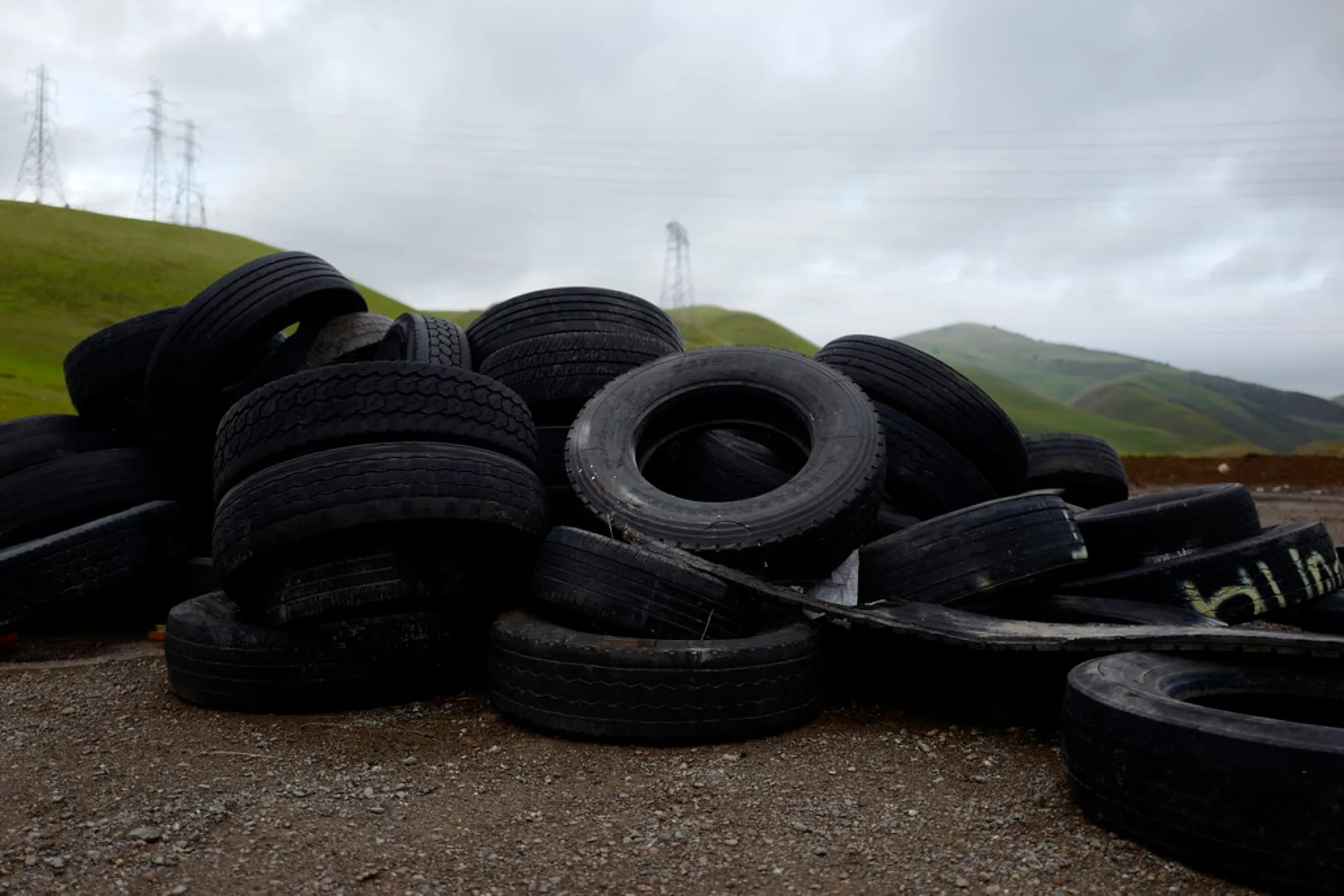 Large stockpile of discarded tyres in an open field (placeholder image)